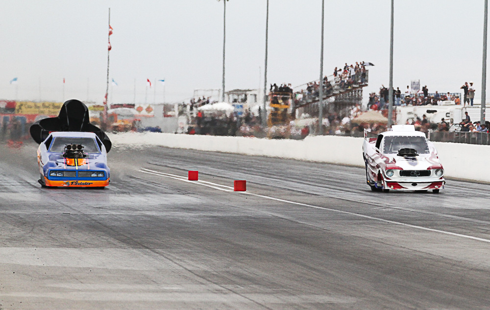 James Day (on the left) pulls his chute as he wins the Funny Car Wally.  Dan Horan, Jr. tries to catch Day and still has pedal to the metal